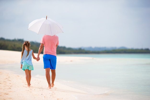 Widok rodziny na plaży z parasolem z tyłu