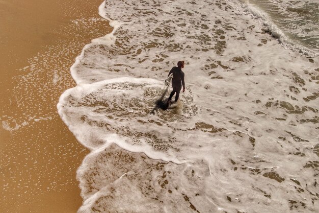 Zdjęcie widok surfera na plaży z wysokiego kąta