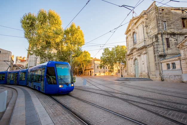 Widok ulicy z kaplicą Saint-Charles i tramwajem podczas zachodu słońca w mieście Montpellier w południowej Francji