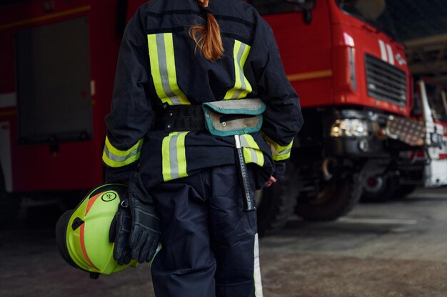 Widok z bliska Kobieta strażak w mundurze ochronnym stojąca w pobliżu ciężarówki