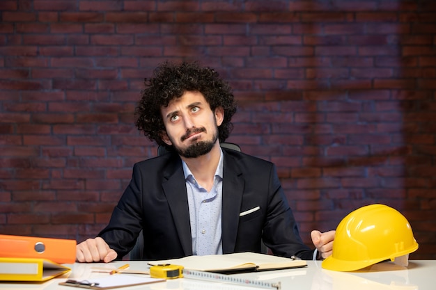 widok z bliska mężczyzna inżynier siedzący za swoim miejscem pracy w garniturze agenda plan pracy budowniczy architektura korporacyjny wykonawca pracownik biznesowy