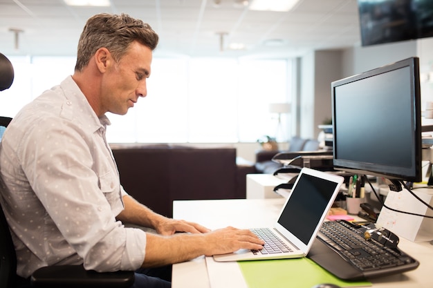Widok z boku biznesmen za pomocą laptopa w biurze