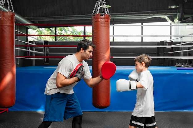 Zdjęcie widok z boku dzieciak ćwiczący boks