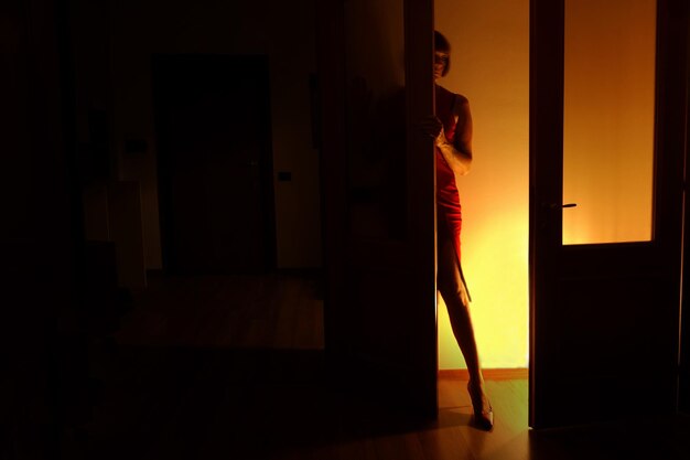 Widok z boku kobiety stojącej przy drzwiach w domu