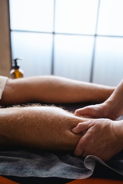 Zdjęcie widok z boku mężczyzna otrzymujący profesjonalny masaż