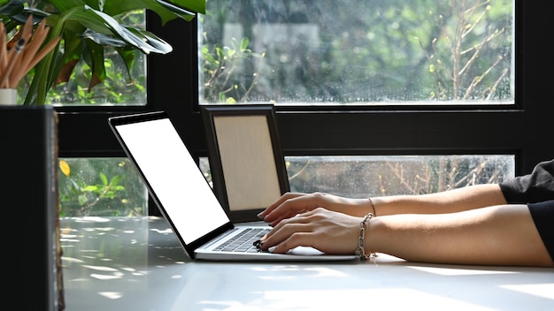 Widok z boku młoda kobieta pracująca online z laptopem w domu Koncepcja stylu życia freelancera