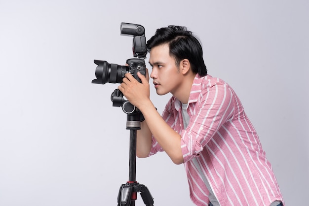 Widok Z Boku Młodego Azjatyckiego Fotografa Trzymającego Aparat Cyfrowy Podczas Pracy W Studio