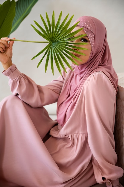 Zdjęcie widok z boku muzułmanka pozuje z rośliną
