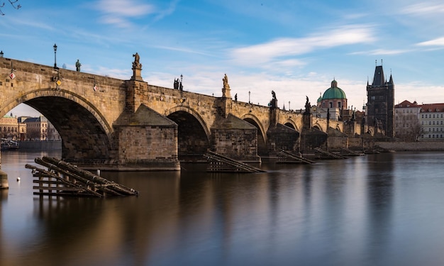 Widok z boku na Most Karola w Pradze nad brzegiem Wełtawy