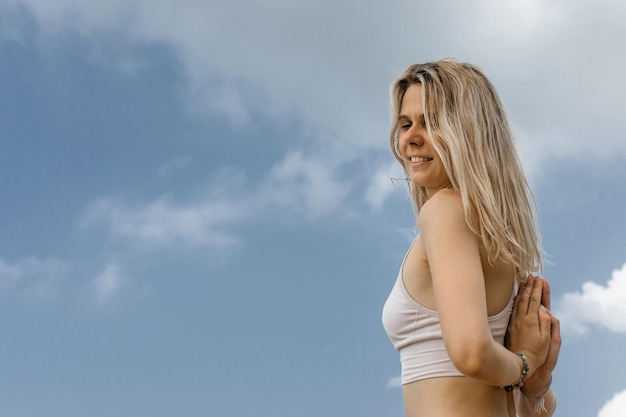 Widok z boku portret kobiety relaksującej oddychania świeżym powietrzem na plaży na tle nieba