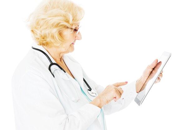 Widok z boku starszej lekarki za pomocą cyfrowego tabletu izolowanego na białym tle