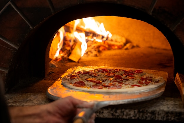 Zdjęcie widok z boku szef kuchni piecze pyszną pizzę