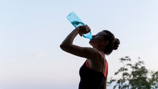 Zdjęcie widok z boku wody pitnej kobieta