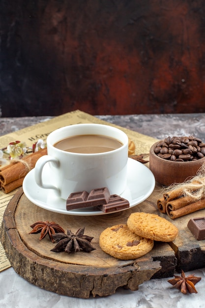 widok z dołu filiżanka herbatników kawowych miska z palonymi ziarnami kawy czekolada laski cynamonu anyż gwiazdkowaty na desce kakao miska na stole
