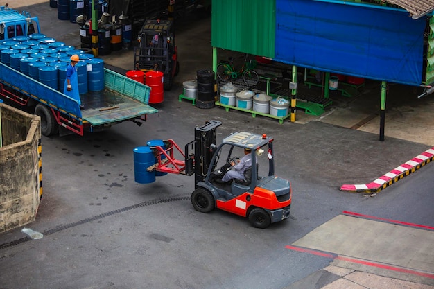 Widok z góry beczki na olej Wózek widłowy porusza się na ciężarówce transportowej mężczyzna pracownik