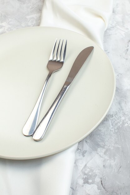 widok z góry biały talerz z widelcem i nożem na jasnym tle kuchnia szkło panie kobiecość jedzenie kolor posiłek poziomy