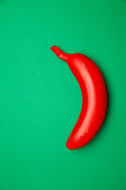 Widok z góry dojrzałego banana pomalowanego na czerwono i umieszczonego na jasnym tle