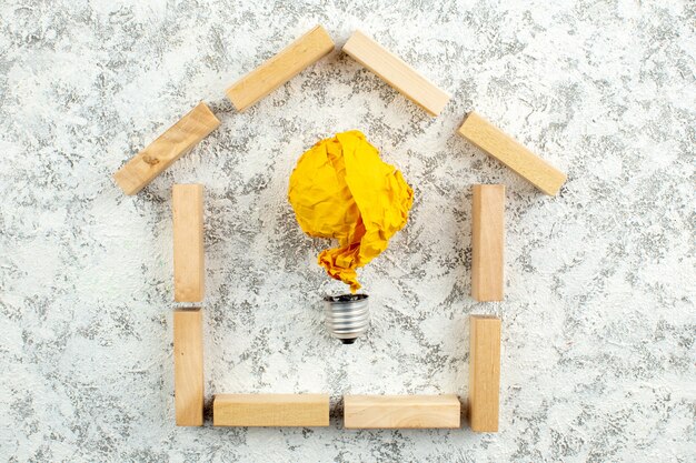widok z góry drewniane klocki kształt domu pomysł koncepcja żarówki z zmiętym papierem na białym szarym tle