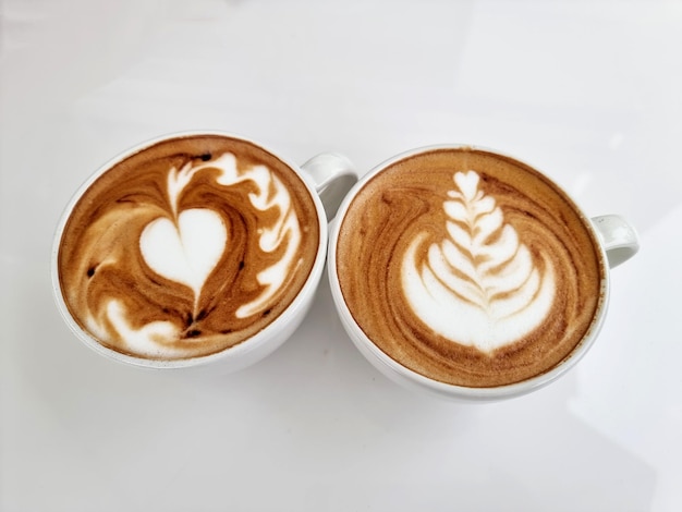 Widok z góry dwie filiżanki gorącej kawy latte art na białym tle