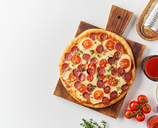 Widok z góry gorąca domowa włoska pizza pepperoni z salami, mozzarellą na białym stole