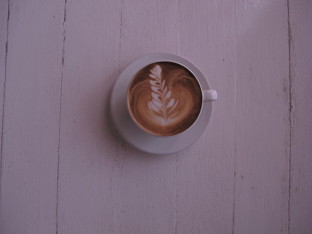 Widok z góry gorącej kawy latte art na biały drewniany stół