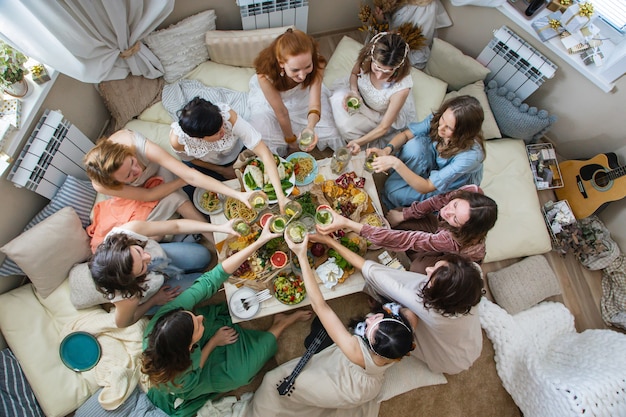 Widok z góry grupa nowoczesnych hipisów koleżanki obchodzi wakacje przy stole serwującym ze zdrową żywnością