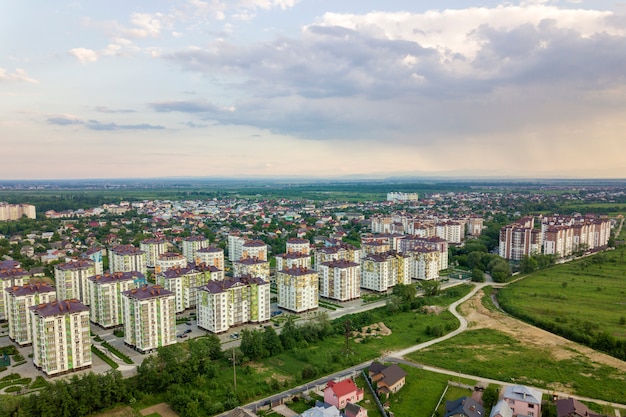 Widok z góry krajobrazu rozwijającego się miasta z wysokimi apartamentowcami i domami na przedmieściach. Fotografia lotnicza dronów.