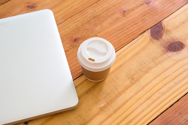 Widok z góry laptopa i filiżankę kawy na tle stołu z drewna