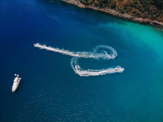 Widok z góry łodzi motorowej, pozostawiając ślad na powierzchni błękitnej wody; koncepcja statków.