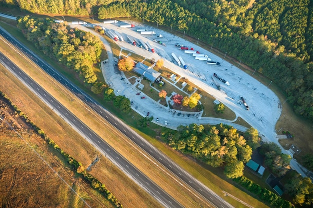 Widok Z Góry Na Duży Parking Dla Samochodów Osobowych I Ciężarowych W Pobliżu Ruchliwej Amerykańskiej Autostrady Z Szybko Poruszającym Się Ruchem Miejsce Rekreacyjne Podczas Podróży Międzystanowych