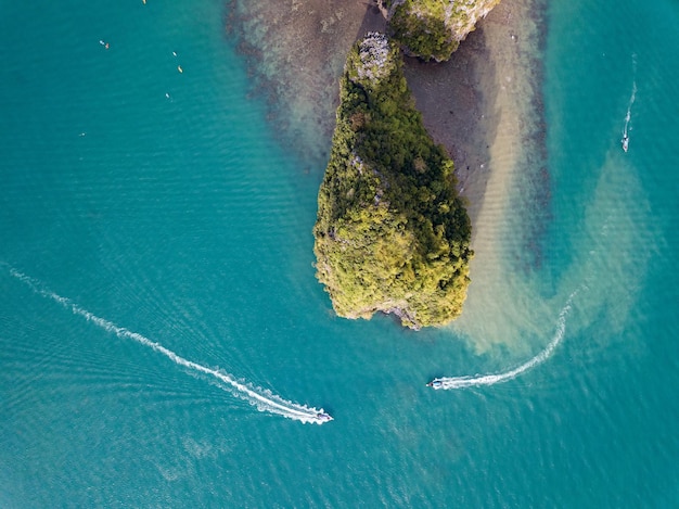 Widok z góry na dwie łodzie krążą wokół skalistej wyspy w tropikalnym morzu Tajlandia