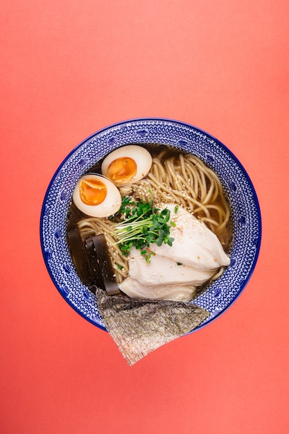 Widok z góry na gęstą zupę z makaronem shio ramen z kurczakiem i jajkami