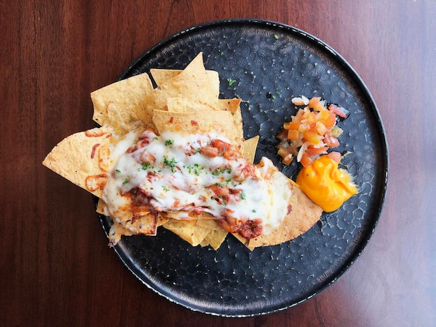 Zdjęcie widok z góry na jedzenie nachos z serem i sosem salsa