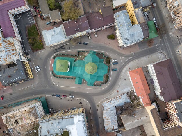 Widok z góry na kopułę kościoła św. Mikołaja Pristika, dachy domów i drogę z zaparkowanymi samochodami, dzielnica Podol. Kijów, Ukraina. Zdjęcie drona