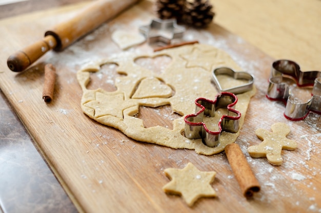 widok z góry na kuchenną deskę z ciastem na pierniki o już wyciętych kształtach