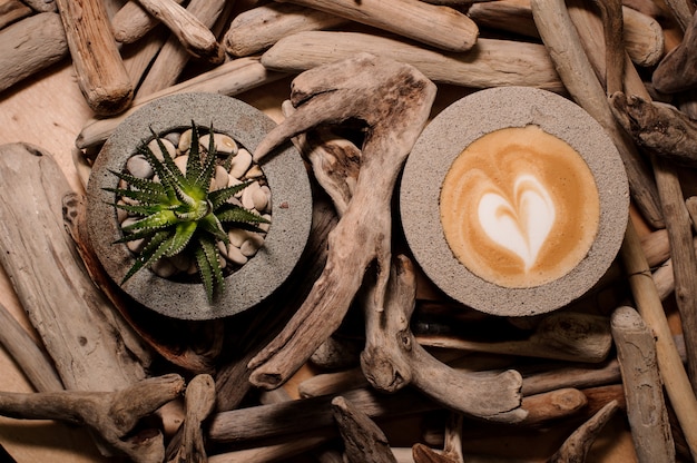 Widok z góry na modne i słodkie betonowe doniczki z napojem kawowym i roślinami