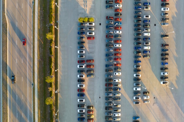 Widok z góry na odkryty parking dealerów z wieloma nowymi samochodami w magazynie na sprzedaż po stronie autostrady Koncepcja rozwoju amerykańskiego przemysłu motoryzacyjnego