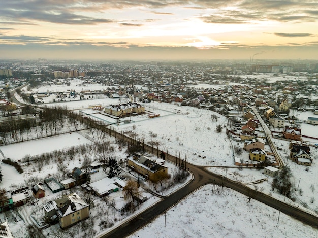 Zdjęcie widok z góry na przedmieścia miasta lub małe miasteczko ładne domy na zimowy poranek na tle zachmurzonego nieba. koncepcja fotografii z lotu ptaka.