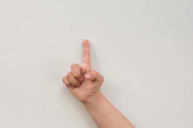 Widok z góry na rękę dziecka pokazującą jeden palec jako numer jeden na białym tle