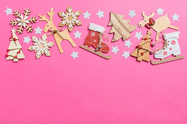 Widok z góry na różowym tle ozdobione świątecznymi zabawkami i symbolami świąt Bożego Narodzenia reniferów i drzew nowego roku. Koncepcja wakacje z miejsca kopiowania
