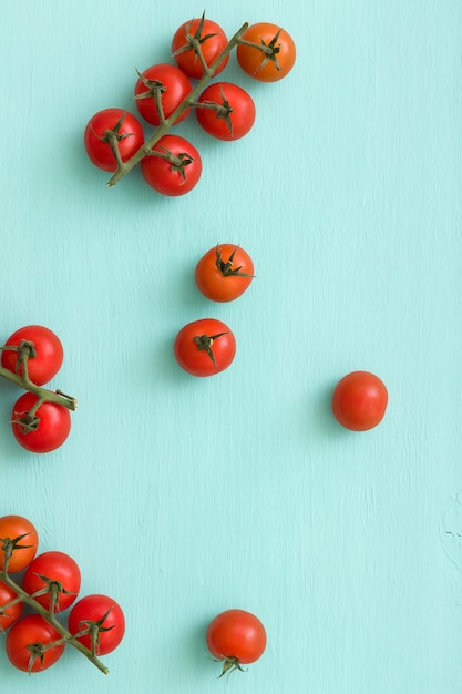 Widok z góry na świeże organiczne pomidory czereśniowe na turkusowym tle Zdrowa żywność i koncepcja jedzenia