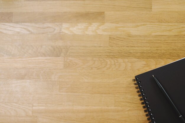 Widok z góry na szkic twarzy w kolorze czarnym notatnik i długopis na drewnianym stole z miejscem na kopię. widok z góry pusty notatnik i tekst.