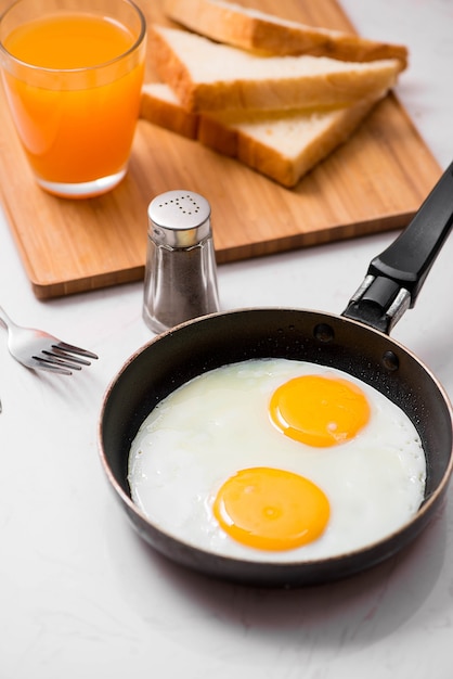 Widok z góry na tradycyjny zdrowy, łatwy, szybki posiłek śniadaniowy z jajek sadzonych podawany na patelni.