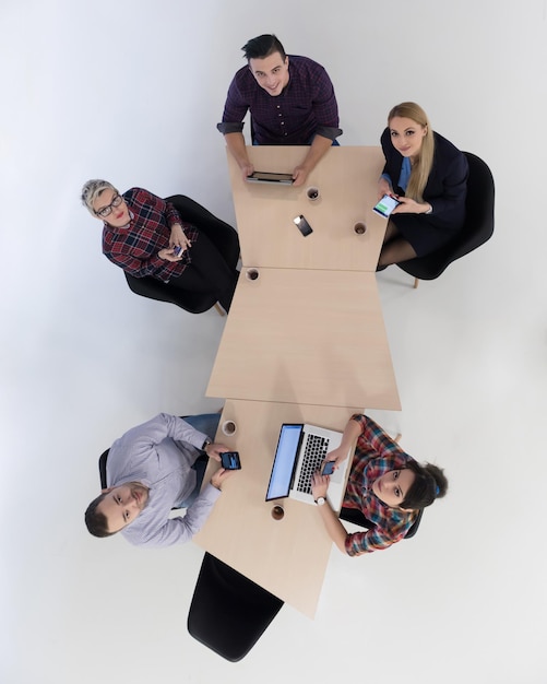 Widok z góry na wieloetniczną grupę ludzi biznesu start-upów na spotkaniu burzy mózgów w nowoczesnym, jasnym wnętrzu biurowym