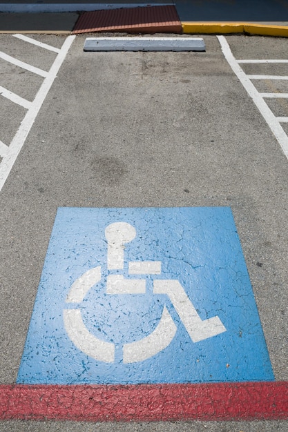 Widok z góry na znak parkingowy dla osób niepełnosprawnych Miejsce parkingowe dla osób niepełnosprawnych i symbole wózków inwalidzkich na asfalcie