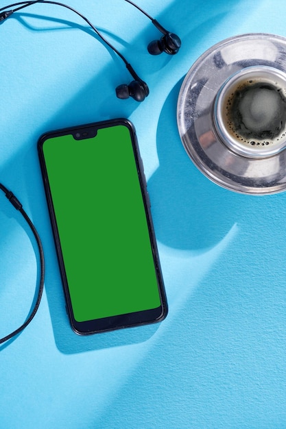 Widok z góry obrazu smartfona ze słuchawkami z pustym ekranem i filiżanką kawy