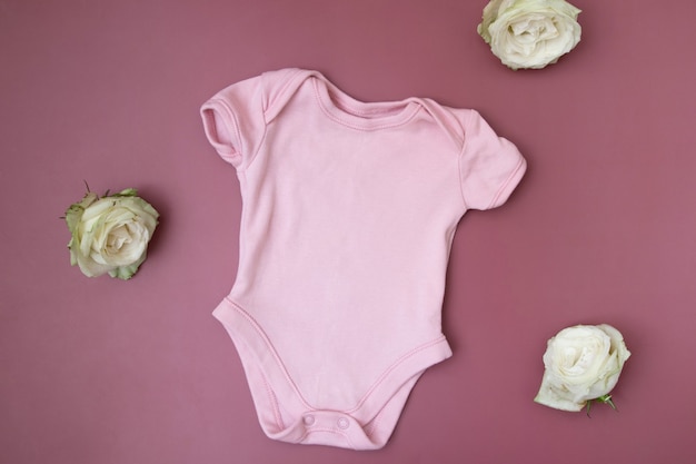 Widok z góry odzieży dziecięcej, makieta różowego body na różowym tle
