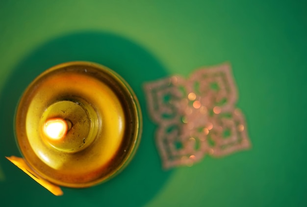 Widok z góry Pelita lub lampa naftowa tradycyjna malajska lampa naftowa zapaliła się podczas muzułmańskich obchodów Ramadanu i Hari Raya Aidilfitri na zielonym tle
