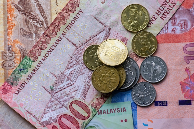 Zdjęcie widok z góry pieniędzy, banknot ringgit malezji, dolar singapurski i riale arabii saudyjskiej na tle. koncepcja biznesowa, finansowa, ekonomiczna i inwestycyjna
