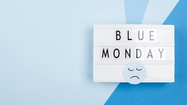 Zdjęcie widok z góry podświetlanego pudełka ze smutną twarzą na niebieski poniedziałek
